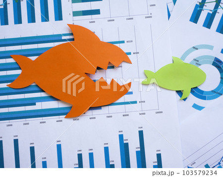 Mergers and acquisitions concept. Two paper fish lie on financial charts. Mergers and acquisitions concept. Two paper fish lie on financial charts. 103579234