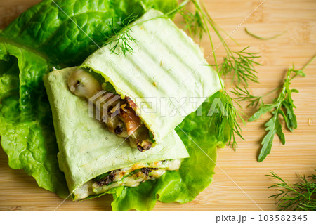 green hot vegetarian pita bread with mushrooms and different vegetables, with lettuce leaves . 103582345