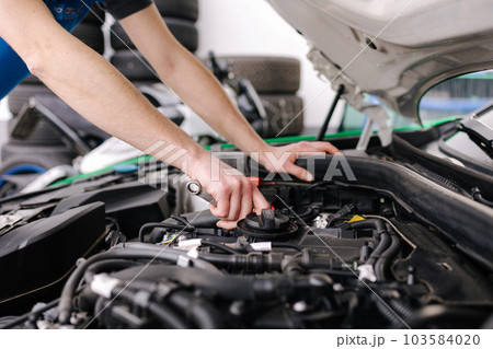 Auto mechanic working in garage. Human hands hold tools. Repair service concept Auto mechanic working in garage. Human hands hold tools. Repair service concept 103584020