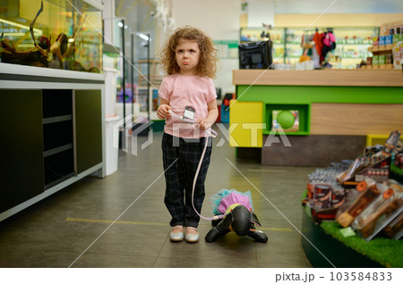 Little girl child at pet shop with toy dog 103584833