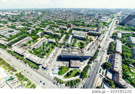 Aerial city view with crossroads and roads, houses, buildings, parks and parking lots. Sunny summer panoramic image Aerial city view with crossroads and roads, houses, buildings, parks and parking lots. Sunny summer panoramic image 103585220