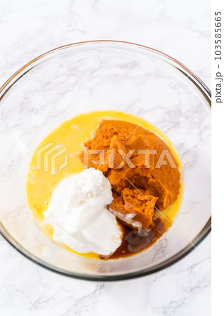 Mixing ingredients in a large glass mixing bowl to bake chocolate pumpkin bundt cake with toffee glaze. Mixing ingredients in a large glass mixing bowl to bake chocolate pumpkin bundt cake with toffee glaze. 103585665