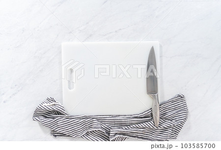 Flat lay. Cutting ingredients on a white cutting board to make classic guacamole dip. Flat lay. Cutting ingredients on a white cutting board to make classic guacamole dip. 103585700