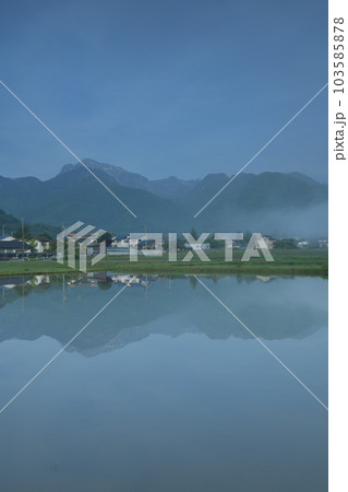 北杜市白州町、晴れ行く霧。水田の水面に映る山並みと街並み 103585878