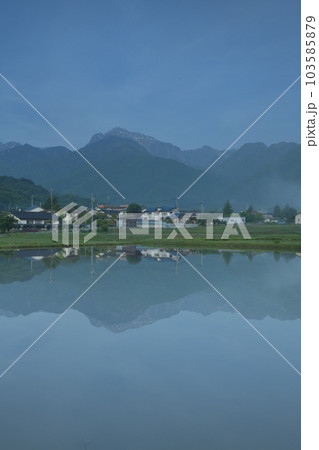 北杜市白州町、晴れ行く霧。水田の水面に映る山並みと街並み 103585879