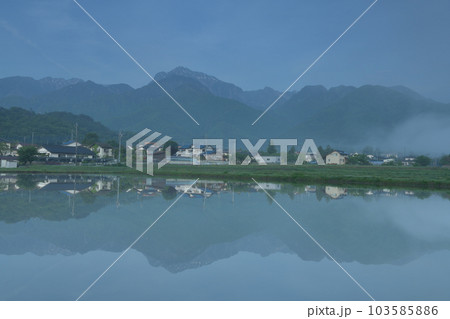 北杜市白州町、晴れ行く霧。水田の水面に映る山並みと街並み 北杜市白州町、晴れ行く霧。水田の水面に映る山並みと街並み 103585886