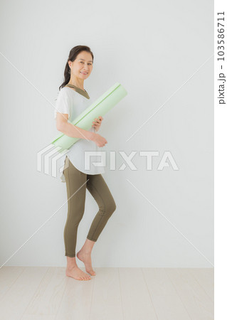 ヨガマットを持ったミドル女性 103586711