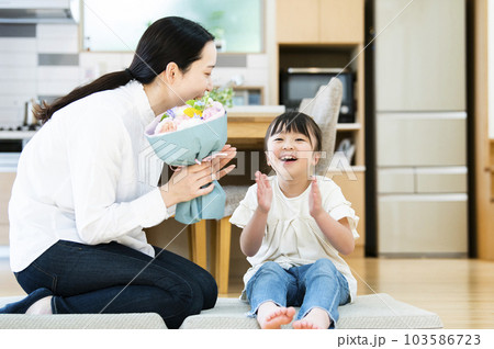 娘に花束をプレゼントされた母親 103586723