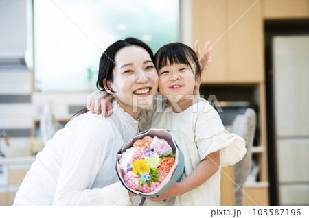 娘に花束をプレゼントされた母親 103587196