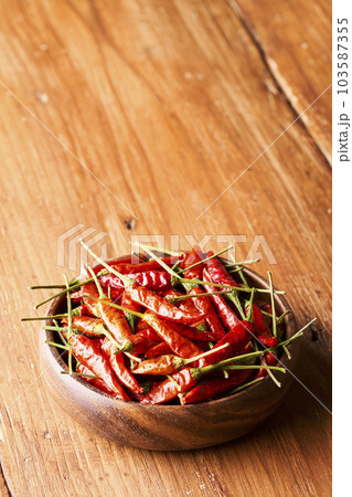 木製皿に盛り付けられた赤トウガラシ 103587355