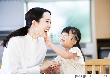 お母さんに保湿クリームを塗る女の子 103587731
