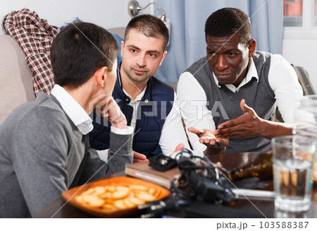 Friends calming distressed guy Friends calming distressed guy 103588387