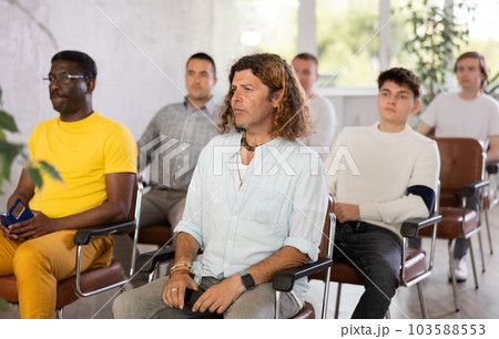 Group of men listening to lecture in auditorium attentively Group of men listening to lecture in auditorium attentively 103588553