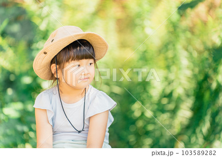 夏休みに森・キャンプ場・アウトドアで遊ぶ子供（帽子）の写真素材