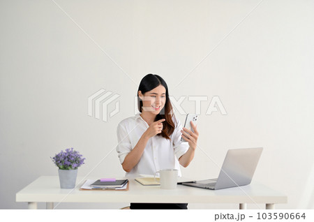 A happy Asian businesswoman is talking with her friends through a video call 103590664