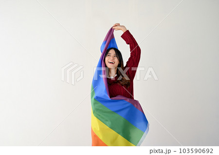A happy young Asian woman with a rainbow LGBT flag. LGBTQ+ pride month 103590692