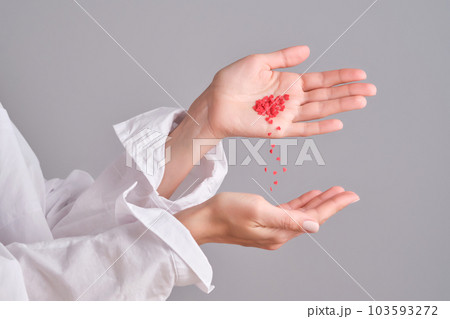 Women's hands with a handful of hearts. Concept. 103593272