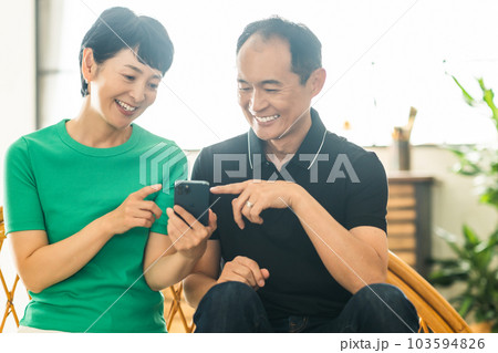 スマホで孫と話すミドル夫婦 スマホで孫と話すミドル夫婦 103594826