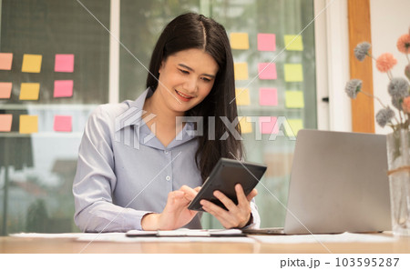 Asian businesswoman sit at their desks and calculate financial graphs showing results about their investments, plan a successful business growth process Asian businesswoman sit at their desks and calculate financial graphs showing results about their investments, plan a successful business growth process 103595287