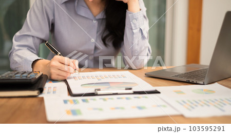 Asian businesswoman sit at their desks and calculate financial graphs showing results about their investments, plan a successful business growth process Asian businesswoman sit at their desks and calculate financial graphs showing results about their investments, plan a successful business growth process 103595291