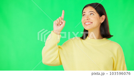 Portrait, point and branding with a woman on a green screen background in studio for marketing or product placement. Hand gesture, advertising and options with an attractive young female on chromakey 103596076