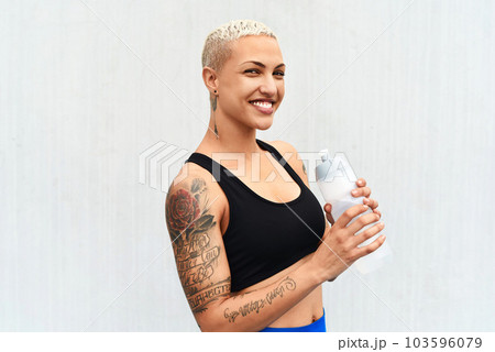 I stay hydrated. Cropped portrait of an attractive young female athlete drinking water against a grey background. I stay hydrated. Cropped portrait of an attractive young female athlete drinking water against a grey background. 103596079