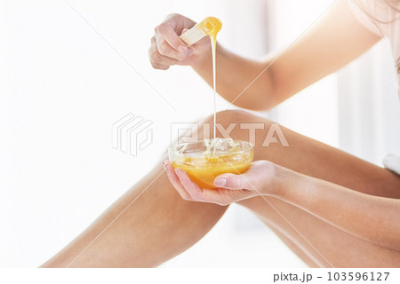 Theyll be smooth to the touch soon. Closeup shot of an unrecognizable woman waxing her legs in the bathroom at home. 103596127