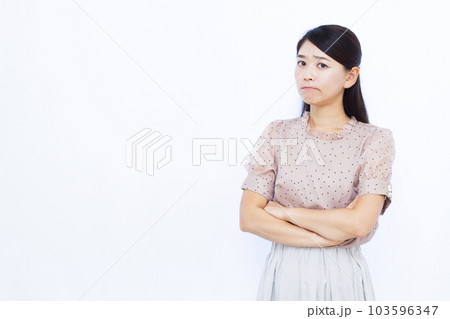 白い背景の前で真剣に悩んでいる30代の女性 103596347