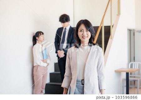 笑顔でオフィスを歩く女性経営者 103596866