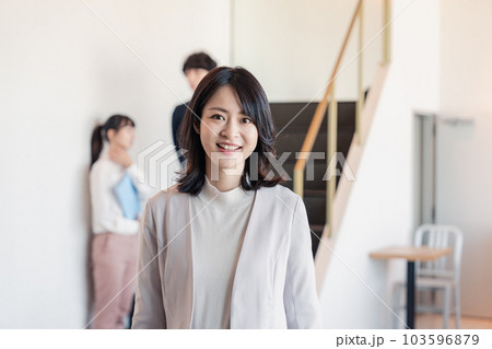 笑顔でオフィスを歩く女性経営者 103596879