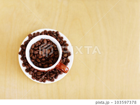 Coffee beans, roasted and cup for cafe industry with quality product and space for marketing or advertising. Above wooden table mockup background with grain as drink, espresso or caffeine ingredient Coffee beans, roasted and cup for cafe industry with quality product and space for marketing or advertising. Above wooden table mockup background with grain as drink, espresso or caffeine ingredient 103597378