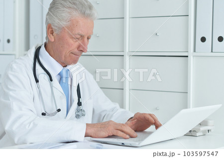 portrait of confident old nice doctor with stethoscope working in office 103597547