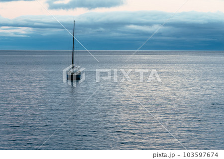 Idyllic image of a sailing yacht anchored in the harbor of Angra do Heroismo harbor at dusk. 103597674