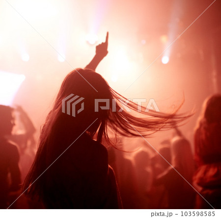 Dancing, club and back of woman at a concert, disco event or psychedelic trance festival. Night, energy and female person doing dance or moving to a song with red light at techno party or show. 103598585