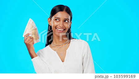 Rich, happy and face of a woman with money isolated on a blue background in a studio. Smile, wealth and a portrait of a girl fanning with cash, lottery jackpot and dollars from a bonus on a backdrop 103599169