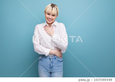 portrait of a young caucasian woman with a short haircut dressed in a white shirt among a blue 103599399
