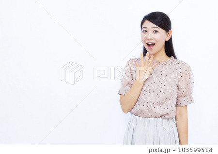 白い背景の前で笑顔でびっくりしている30代の女性 103599518