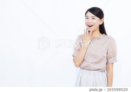白い背景の前で笑顔でびっくりしている30代の女性 103599520