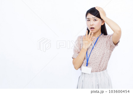 白い背景の前で頭を抱えて驚く30代の働く女性 103600454