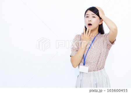 白い背景の前で頭を抱えて驚く30代の働く女性 103600455