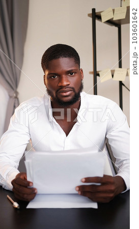 Professional leadership. Office paperwork. Confidence expertise. Young business man CEO discussing documents in hands at table in modern interior. 103601642