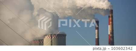 CHP cooling towers from which smoke is coming out against blue sky 103602342