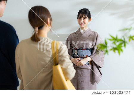 着物の女将に案内されるカップル 103602474