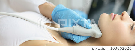 Doctor diagnoses thyroid gland on ultrasound machine closeup 103602620