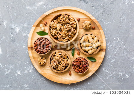 Walnut kernel halves, in a wooden bowl. Close-up, from above on colored background. Healthy eating Walnut concept. Super foods with copy space 103604032