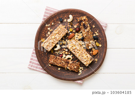 Various granola bars on table background. Cereal granola bars. Superfood breakfast bars with oats, nuts and berries, close up. Superfood concept Various granola bars on table background. Cereal granola bars. Superfood breakfast bars with oats, nuts and berries, close up. Superfood concept 103604185