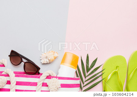 Beach accessories straw hat and seashell on colored table. Summer concept background Beach accessories straw hat and seashell on colored table. Summer concept background 103604214