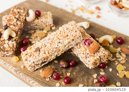 Various granola bars on table background. Cereal granola bars. Superfood breakfast bars with oats, nuts and berries, close up. Superfood concept 103604529