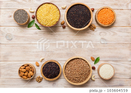 Various superfoods in smal bowl on colored background. Superfood as rice, chia, quinoa, lentils, nuts, sesame seeds, almonds. top view copy space 103604559