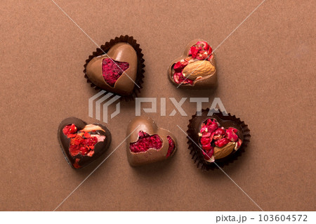 chocolate sweets in the form of a heart with fruits and nuts on a colored background. top view with space for text, holiday concept 103604572